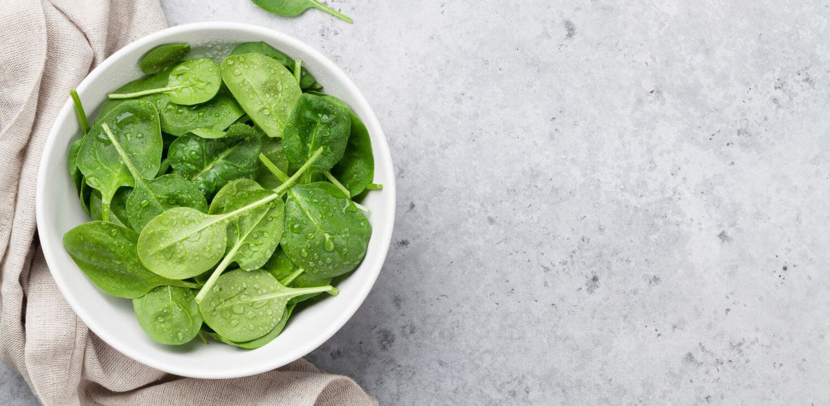 A white bowl filled with green leafy vegetables