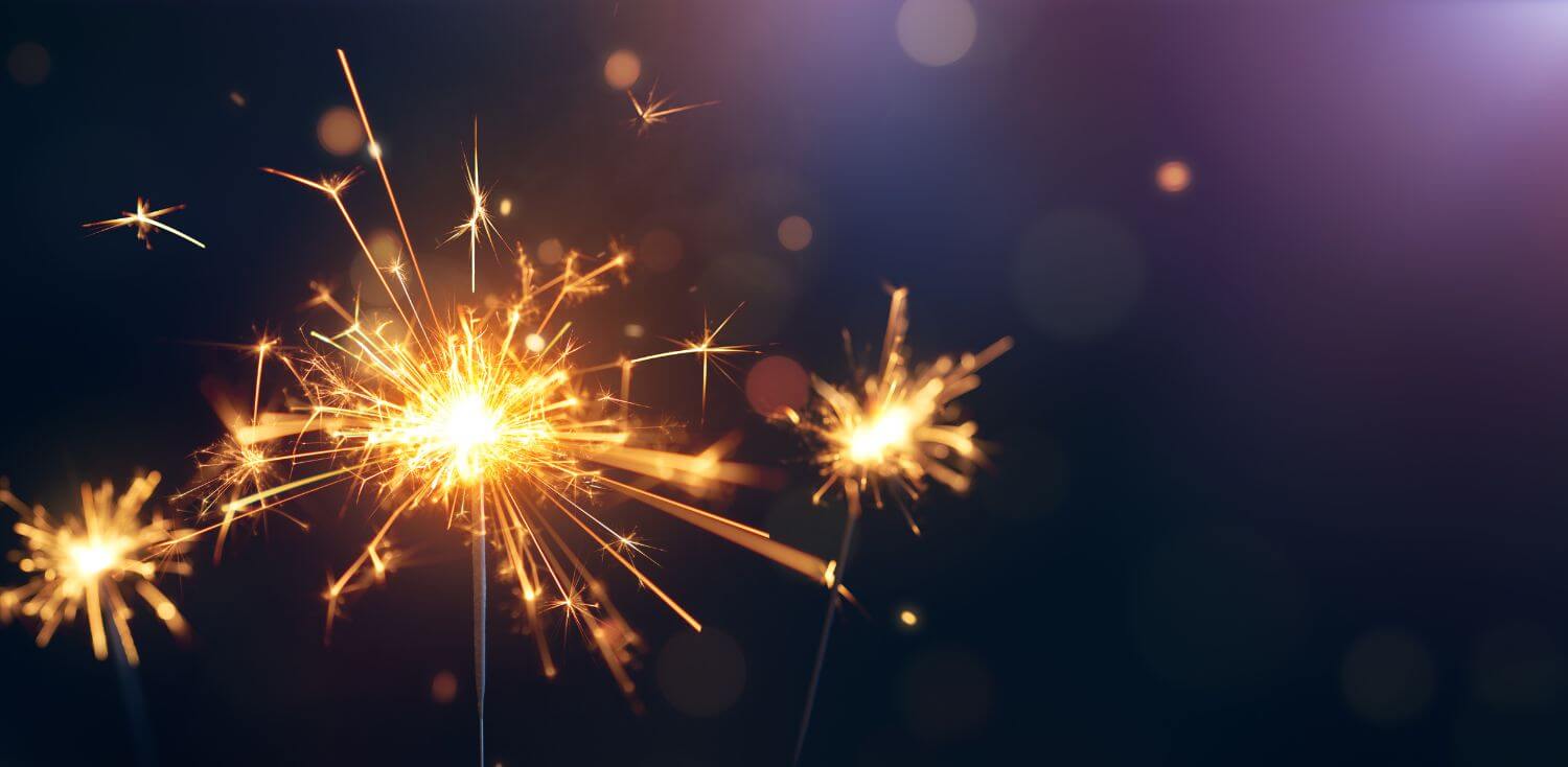 A close up of a sparkler on a black background.