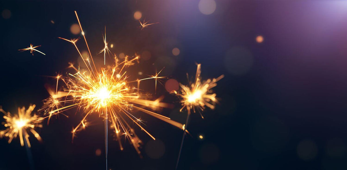 A close up of a sparkler on a black background.