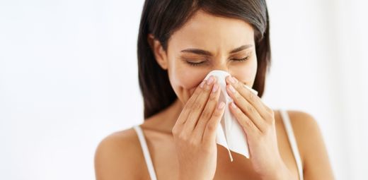 A woman blowing her nose with a napkin