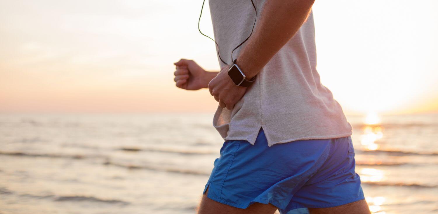 A man running on the beach at sunset