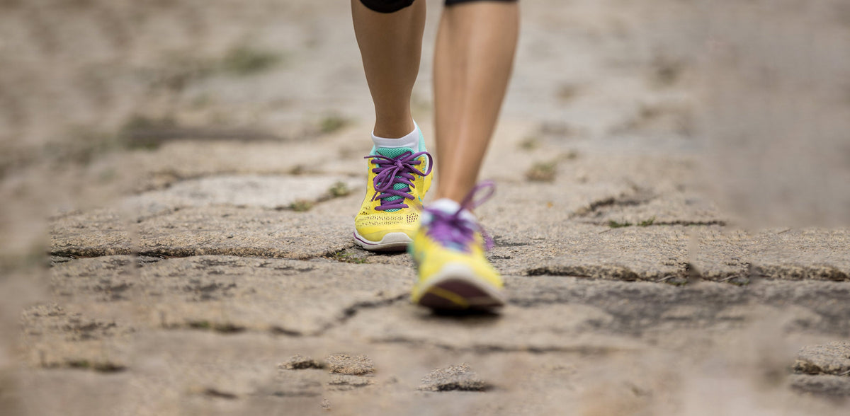 A close up of a person running on a dirt road