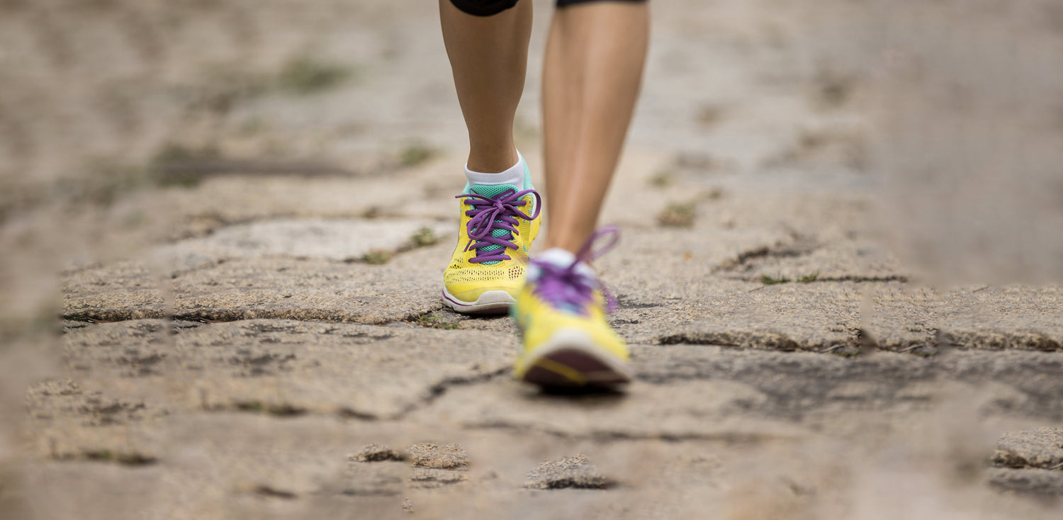 A close up of a person running on a dirt road