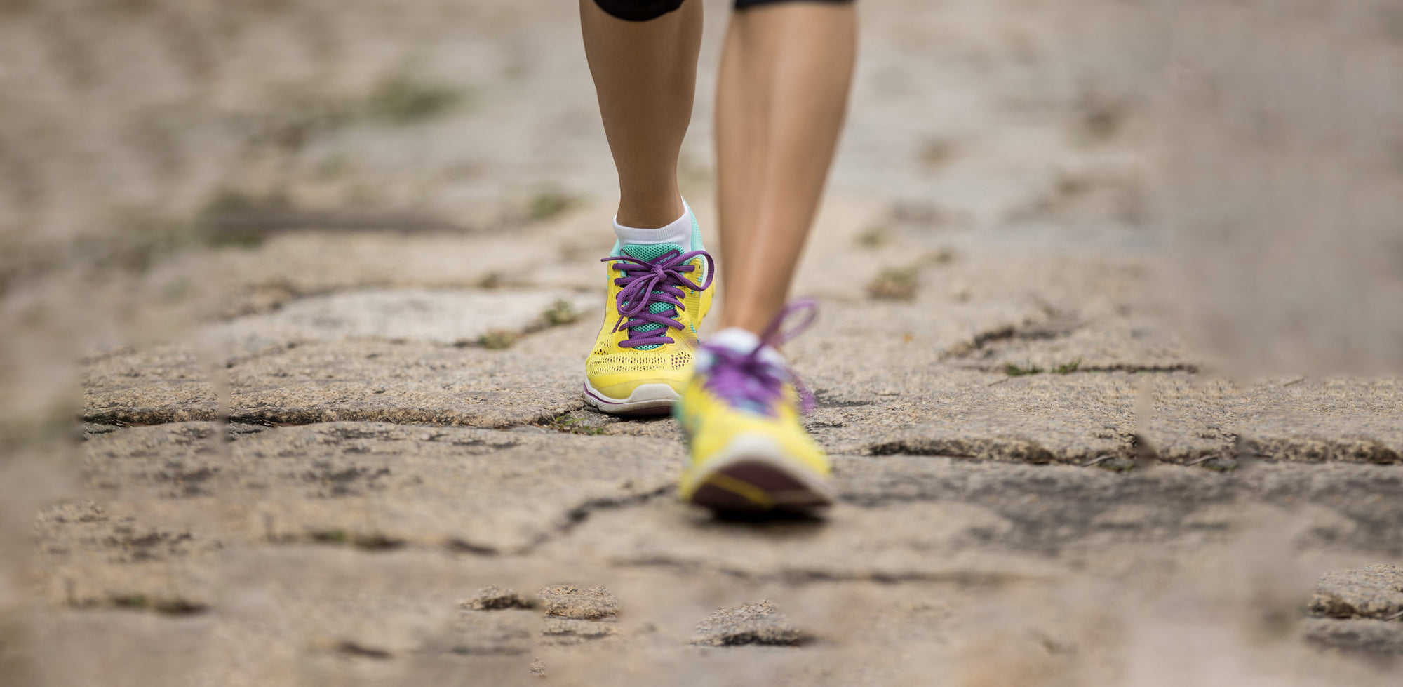 A close up of a person running on a dirt road