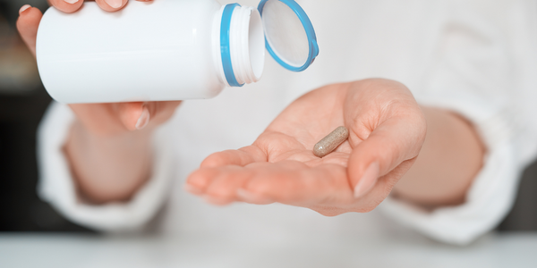 A person holding a pill in their hand