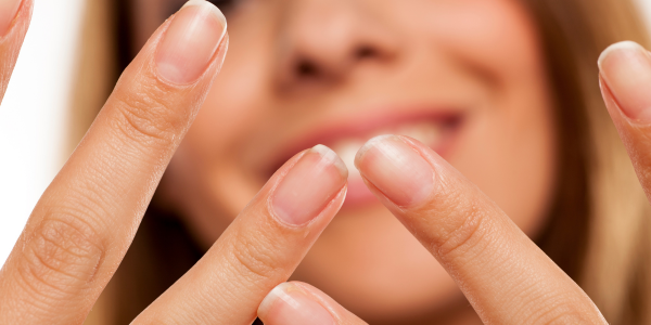 Close-up of a woman’s hands showing her clean, natural fingernails.