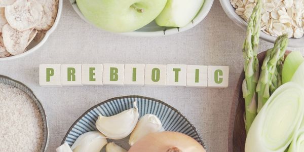 A table topped with bowls filled with food and wood cubes that say Prebiotic.