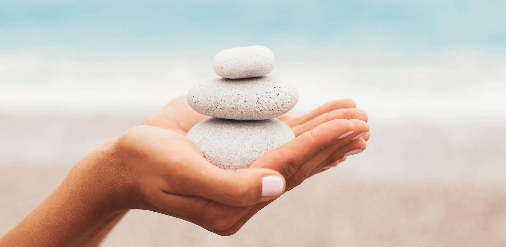 A person holding a stack of rocks in their hand