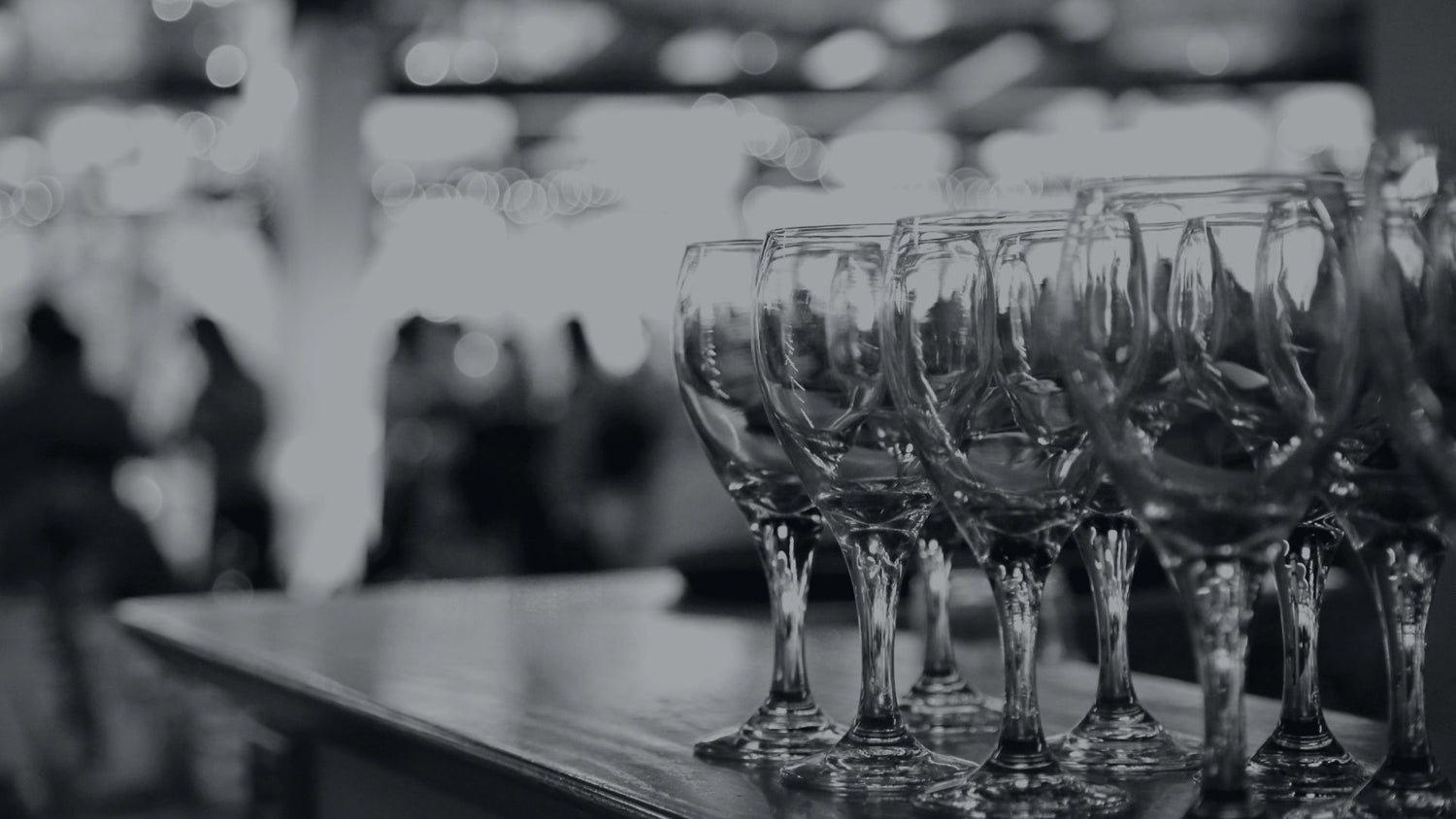 A row of wine glasses sitting on top of a bar