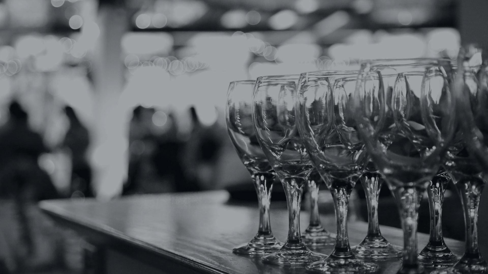 A row of wine glasses sitting on top of a bar