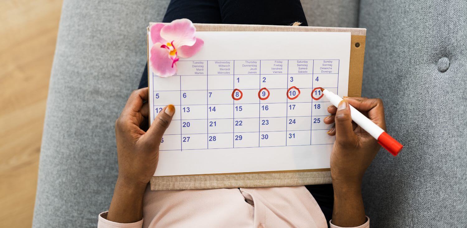 A woman holding a calendar with a flower on it.