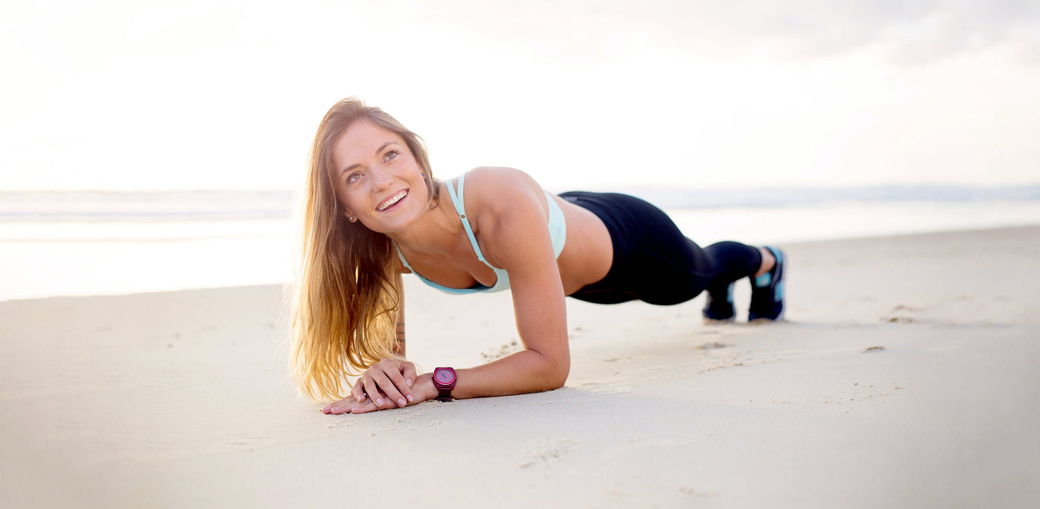 A woman is doing push ups on the beach