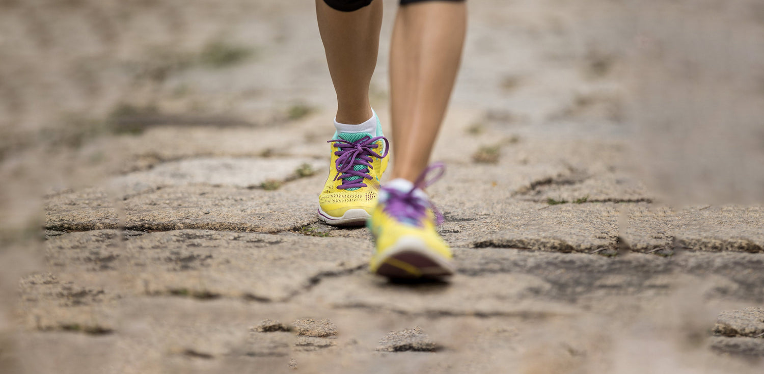A close up of a person running on a dirt road