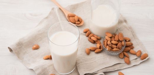 Two glasses of milk and almonds on a napkin
