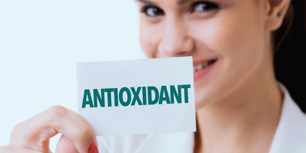 A woman holding a business card with the word antioxidant printed on it