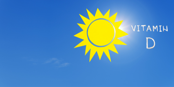 A bright yellow sun against a blue sky with the words “Vitamin D” written beside it.