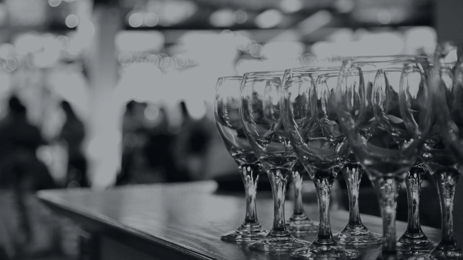A row of wine glasses sitting on top of a bar